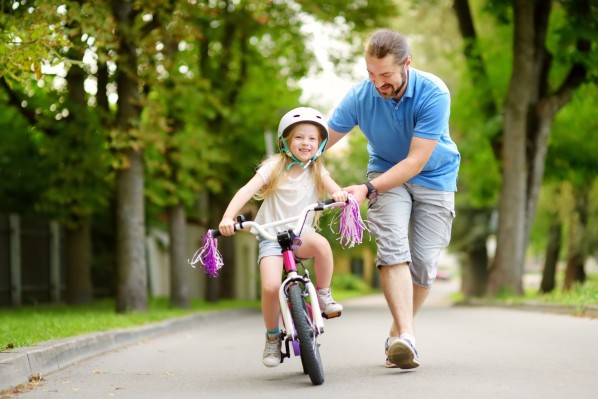 Vater übt mit Tochter Radfahren