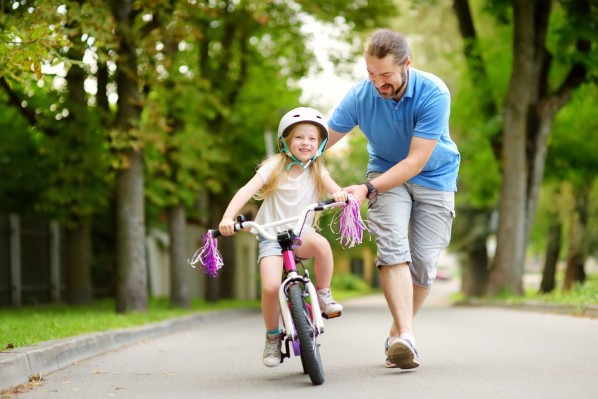 Vater übt mit Tochter Radfahren