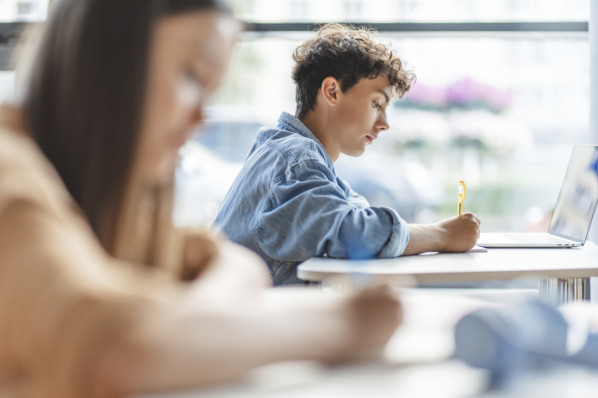 Nachdenklicher, intelligenter Teenager mit Laptop