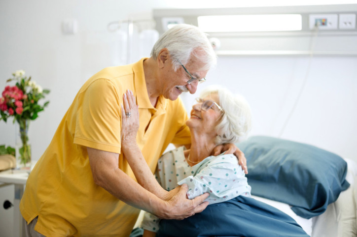 Ein Senior besucht seine Frau im Krankenhaus nach einer Implantat-Operation