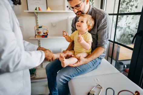 Kleinkind mit Vater beim Impfen beim Kinderarzt