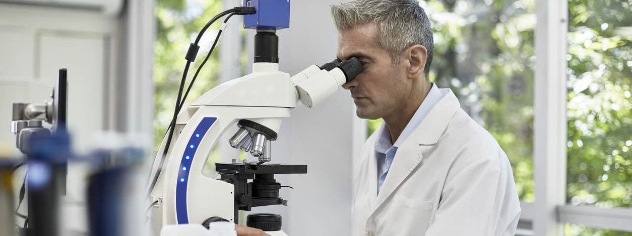 Neuer Pathologe schaut in ein Mikroskop