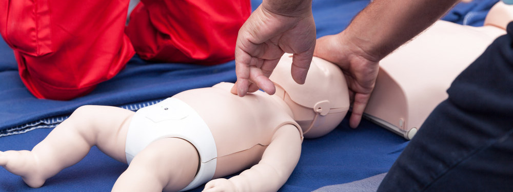 Kinder-Erste-Hilfe wird an einer Babypuppe geübt