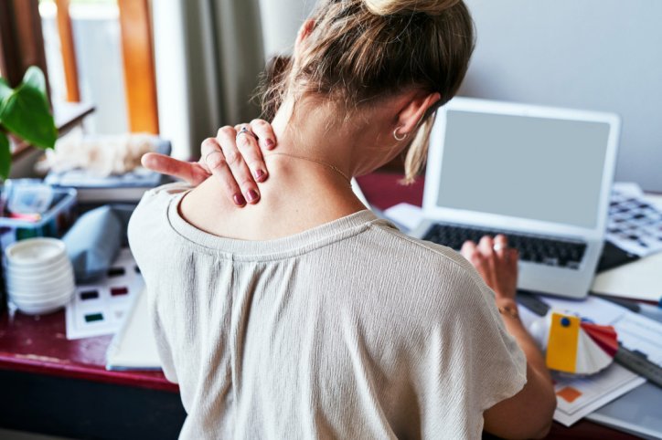 Eine Frau leidet aufgrund einseitiger Haltung unter schmerzenden Triggerpunkten
