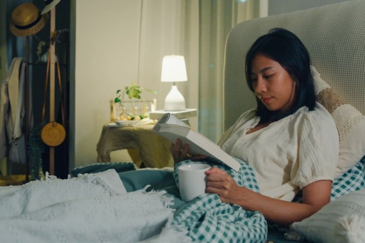 Frau hält Schlafhygiene im Bett ein.