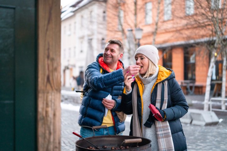 Ein Paar probiert frische Maronen an einem Straßverkauf