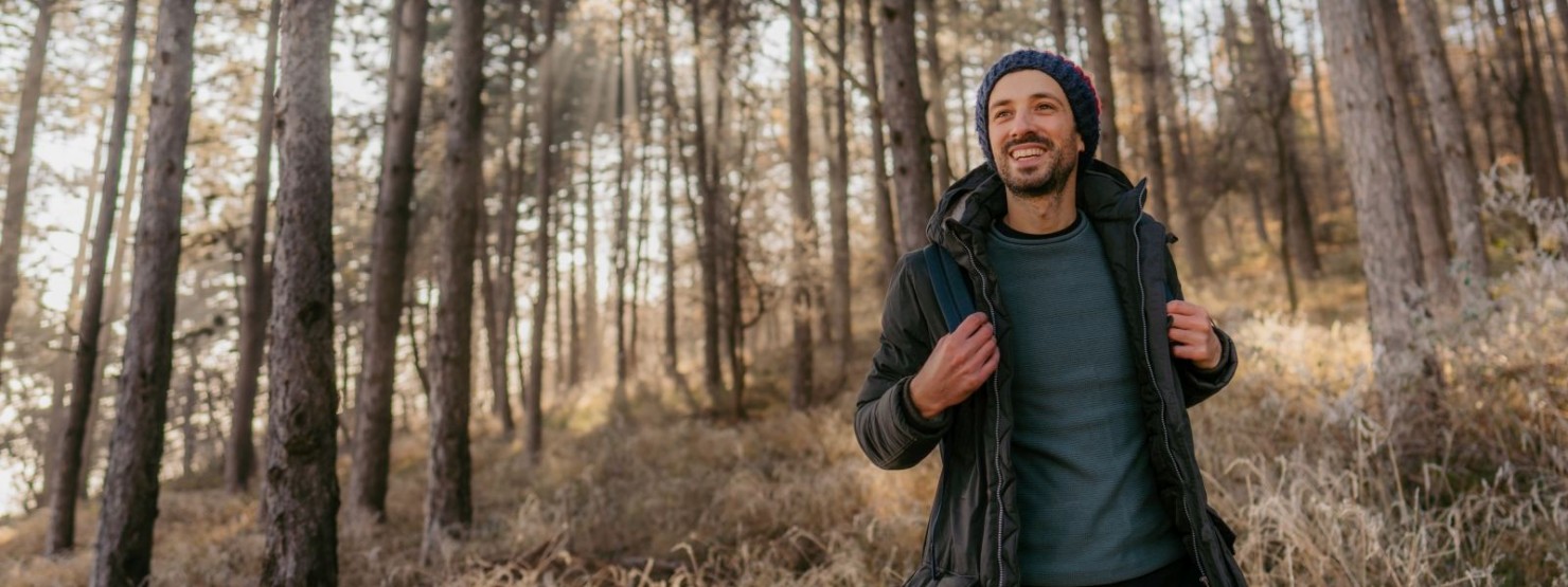 Ein mann anfang 30 wandert motiviert im Wald