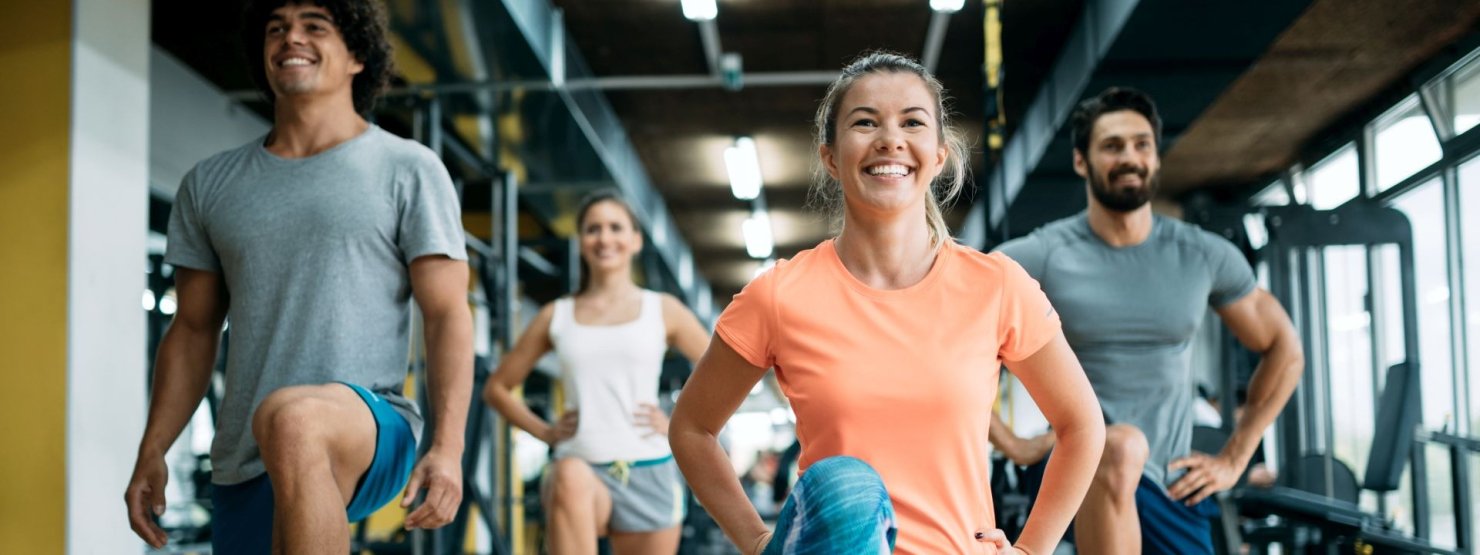 Gruppe mit zwei Männern und 2 Frauen beim Training im Fitnessstudio auf Step-Brettern