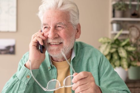 Ein lächelnder Rentner telefoniert.