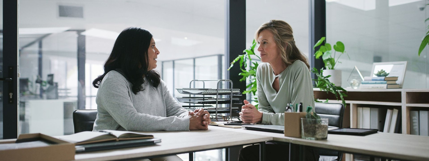Eine Führungskraft spricht mit ihrer Mitarbeiterin über ihre Fehlzeiten auf Arbeit.