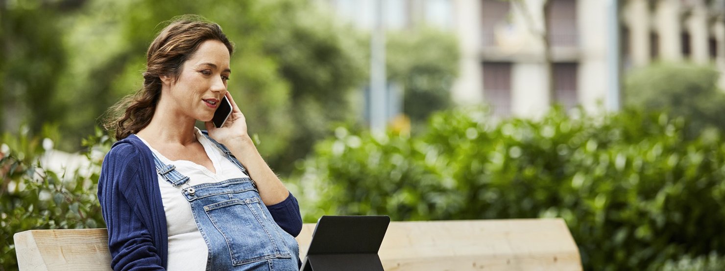 Eine Frau sitzt vor einem Laptop und nimmt telefonisch Kontakt zur AOK Sachsen-Anhalt auf