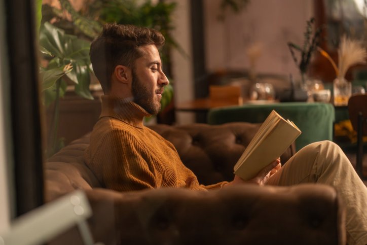 Ein Mann liest anstelle von Doomscrolling ein Buch