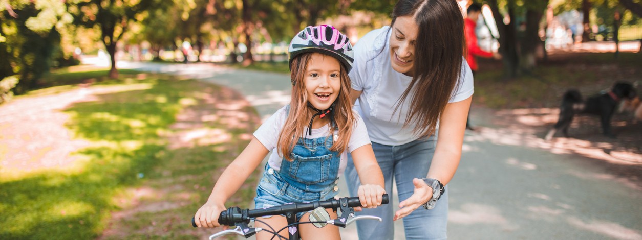 Ein Vater bringt seinem etwa 6 jährigen Sohn das Fahrradfahren bei.