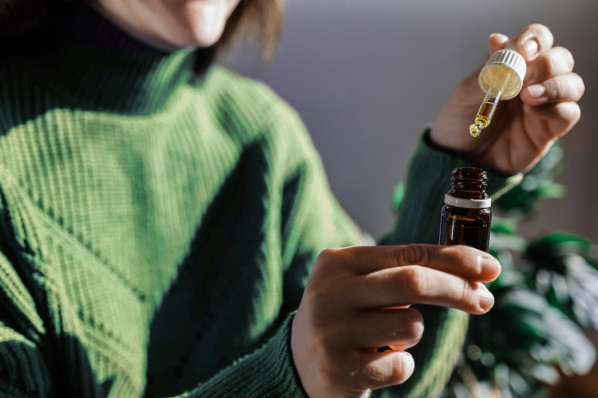 Frau entnimmt mit Pipette pflanzliches Arzneimittel