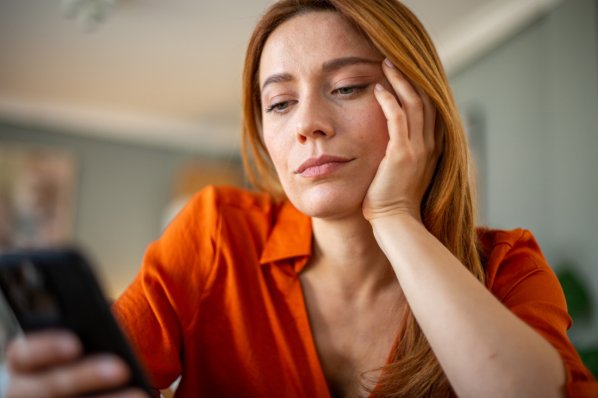 Frau wartet Nachricht am Telefon