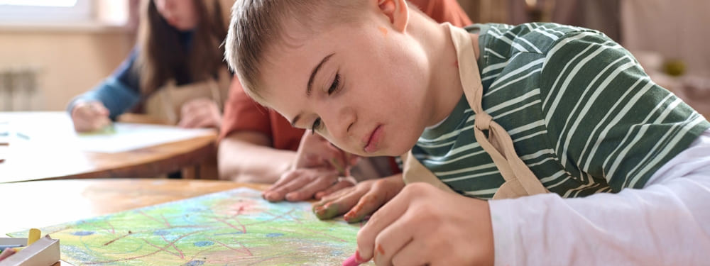Ein Junge hat aufgrund einer Farbenblindheit Probleme beim Malen mit Farben