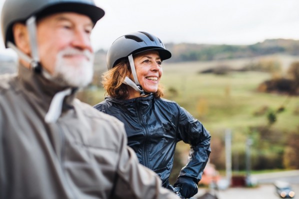 Älteres ehepaar mit Fahrradhelm und Regenjacken