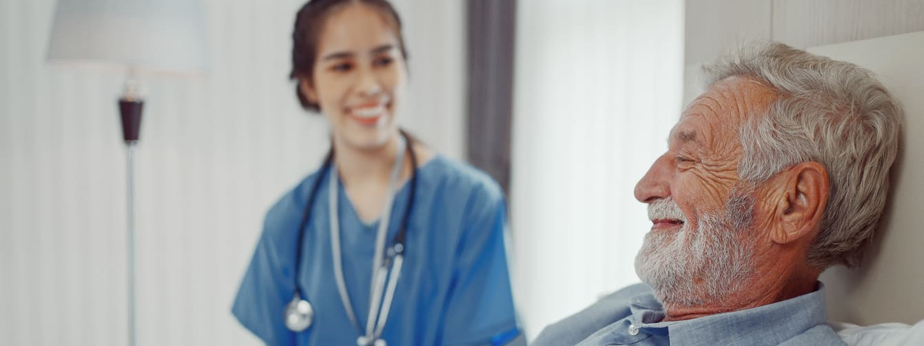 Junge Ärztin auf Pflegevisite bei älterem Patienten
