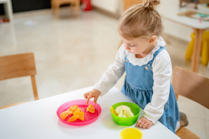 Ein kleines Mädchen hat Schwierigkeiten mit der Feinmotorik
