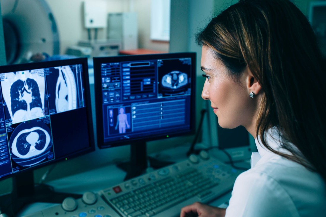 Eine Ärztin schaut sich CT-Bilder auf zwei Bildschirmen an.