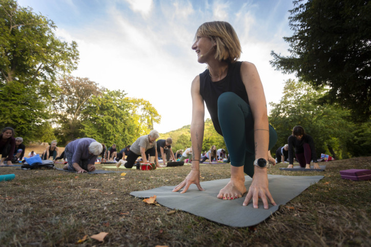 Yogatrainerin leitet Teilnehmer der Yogaschule an