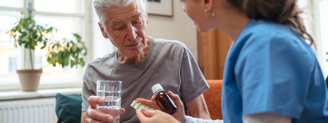 Ein Senior erhält ein Placebomedikament von einer Ärztin.