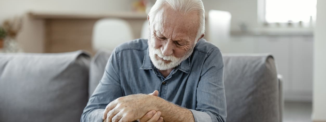 Ein Senior hat aufgrund von Gicht schmerzende Handgelenke