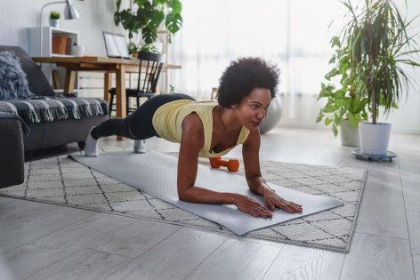 Frau führt funktionelles Training Zuhause durch