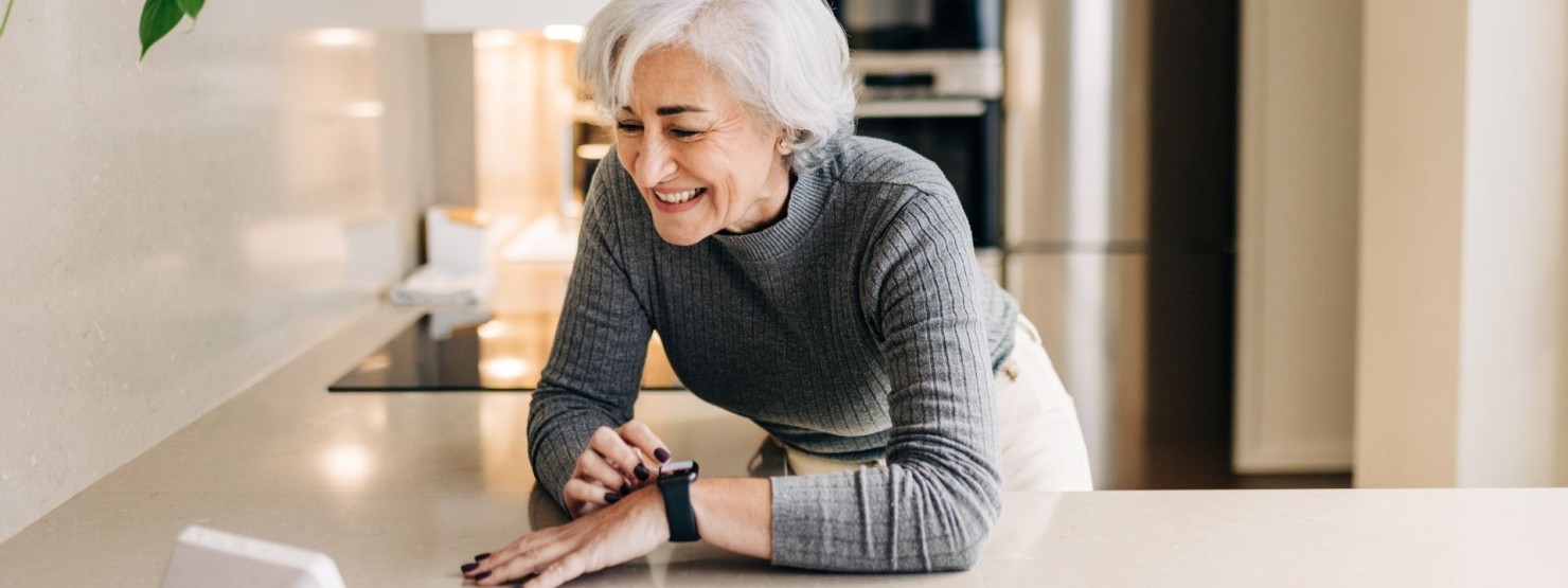 Eine Seniorin überprüft ihre Vitalwerte mit einer Smartwatch.