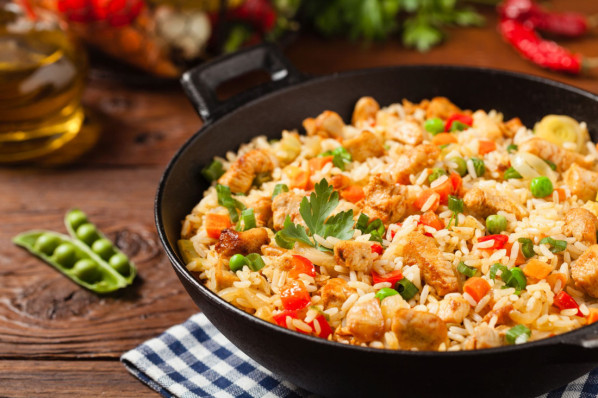 Eine Pfanne mit frisch gekochtem reis und Hähnchen.