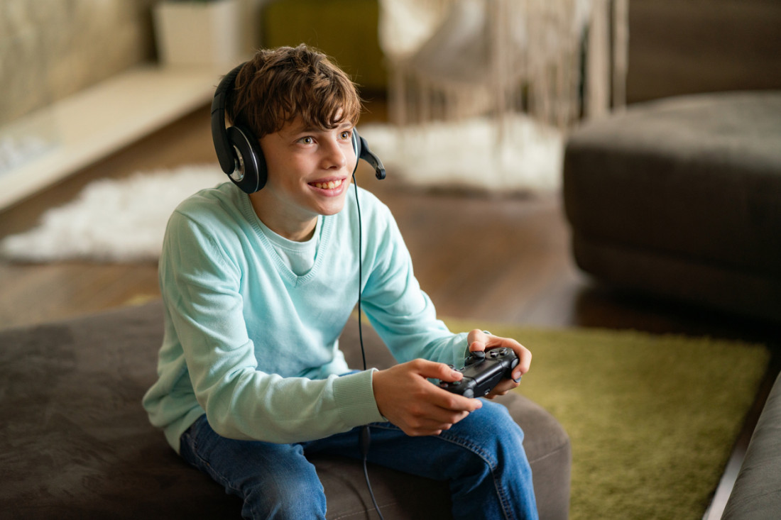 Ein Jugendlicher spielt auf der Spielkonsole ein Onlinespiel.