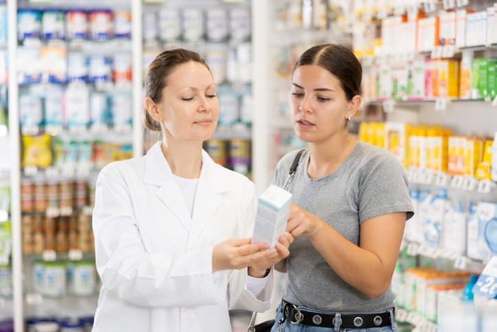 Eine Frau wird von einer Apothekerin zu einem Arzneimittel beraten.