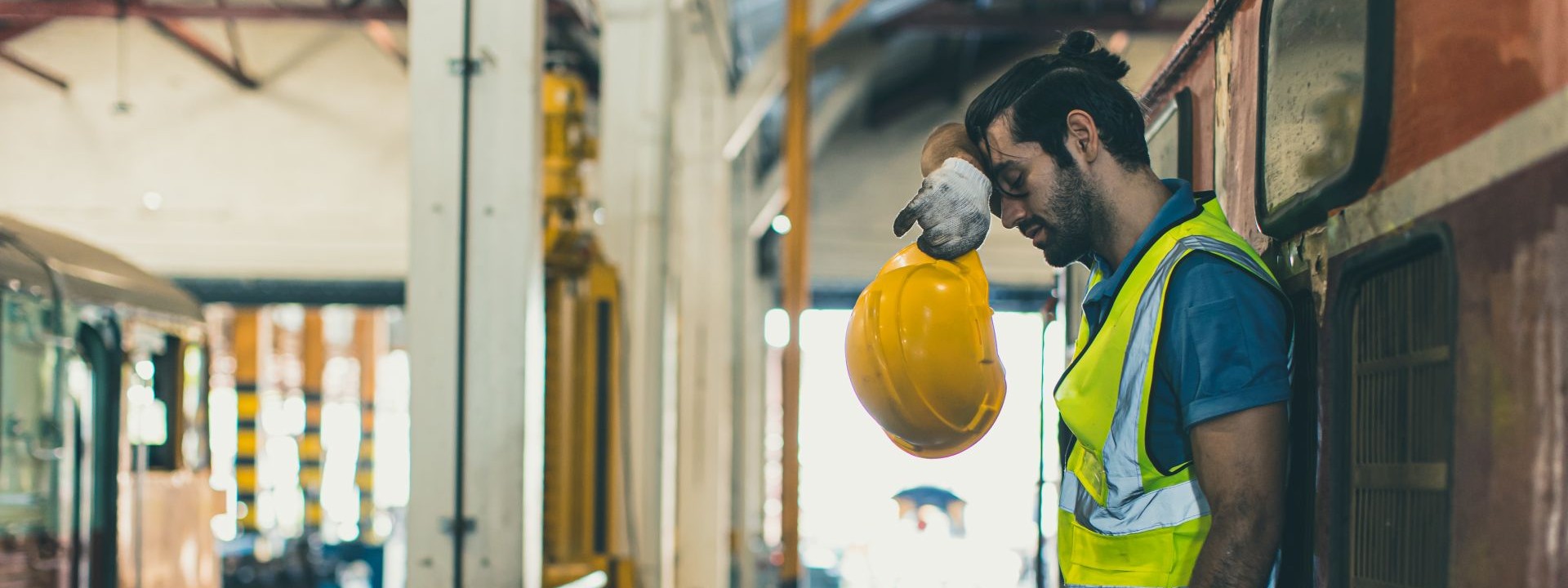 Ein erschöpfter Arbeiter lehnt an einer Wand