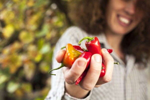 Eine Frau hält in ihren Händen einige Chilischoten.