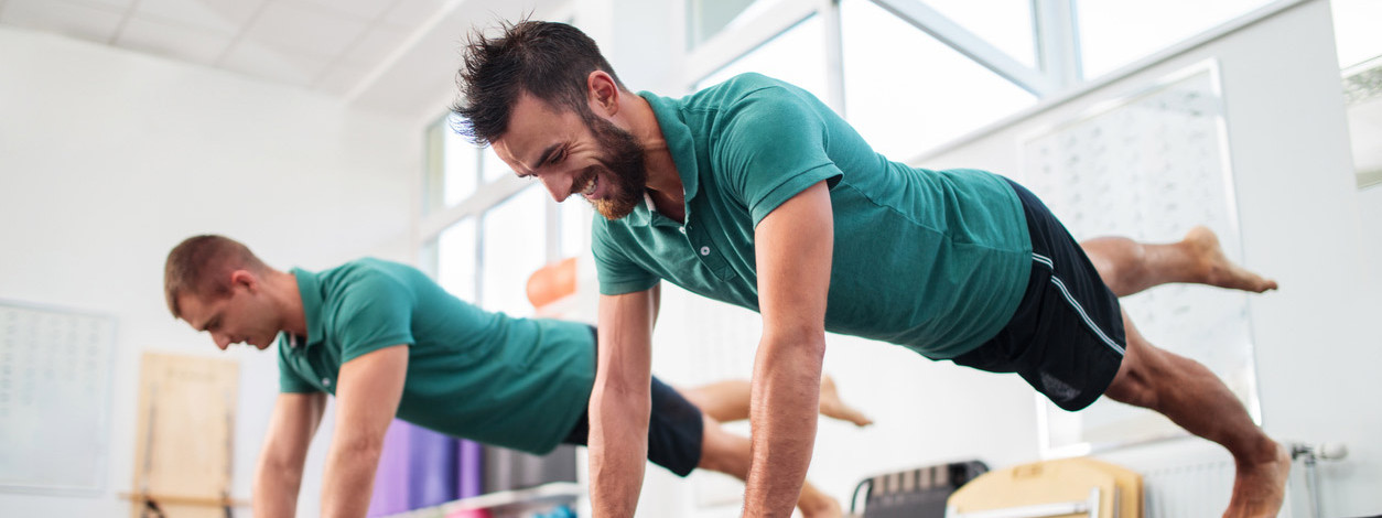 Zwei Männer machen gemeinsam Lagree-Fitness