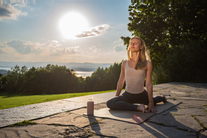 Eine Frau übt Yin Yoga bei Sonnenuntergang aus