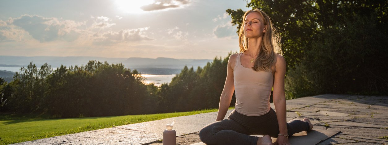 Eine Frau übt Yin Yoga bei Sonnenuntergang aus