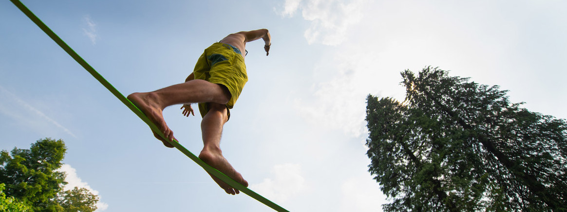 Ein Mann balanciert auf einer Slackline