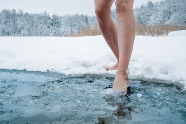 Eine Person geht in einem vereisten See baden.