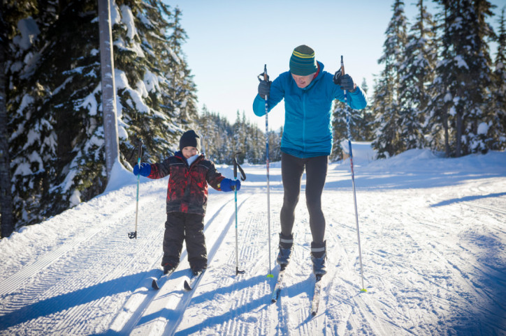 Älterer Mann und sein zirka 5-jähriger Enkel beim Skilanglauf