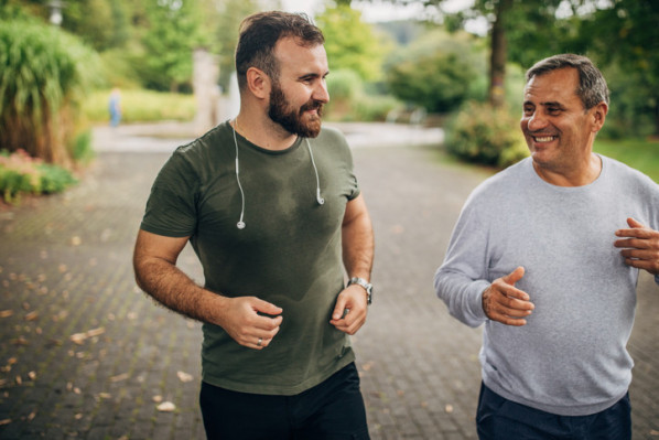 Vater und Sohn joggen gemeinsam im Grünen