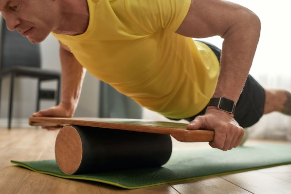 Mann macht Liegestütze auf balance Board