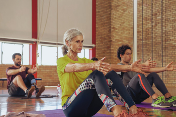 Frau und zwei Männer beim Sportkurs in der Sporthalle
