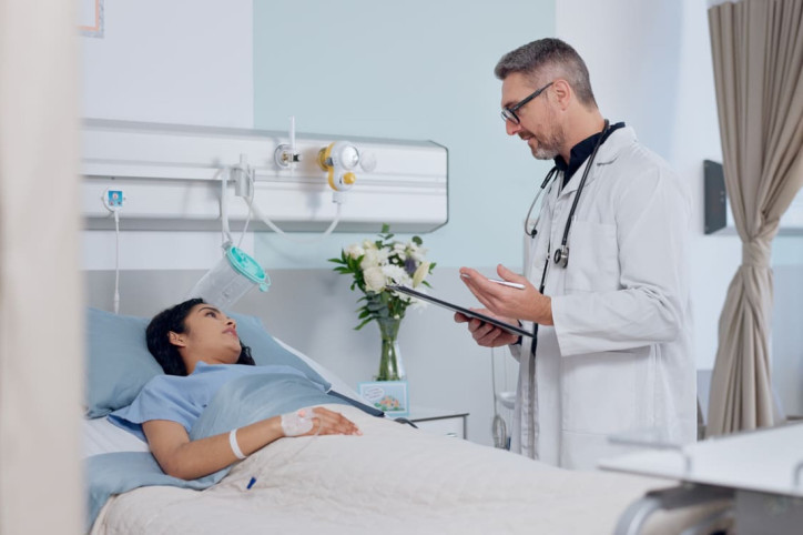 Ein Facharzt erklärt einer Patientin den Ablauf einer Biopsie