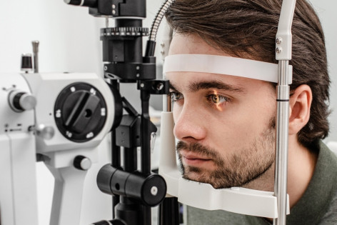 Ein Mann wird der KI-gestützten Diagnosegerät „Eyelib“ am Auge untersucht.