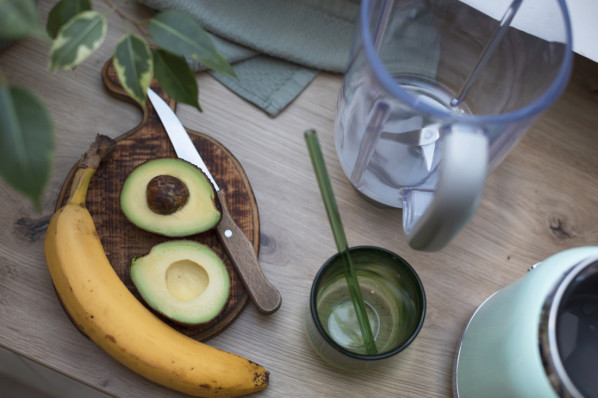 aufgeschnittene Avocado und banane auf einem Holzbrett