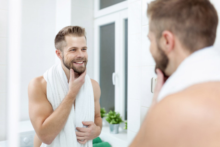Ein Mann freut sich über straffere Haut dank Gesichtsyoga