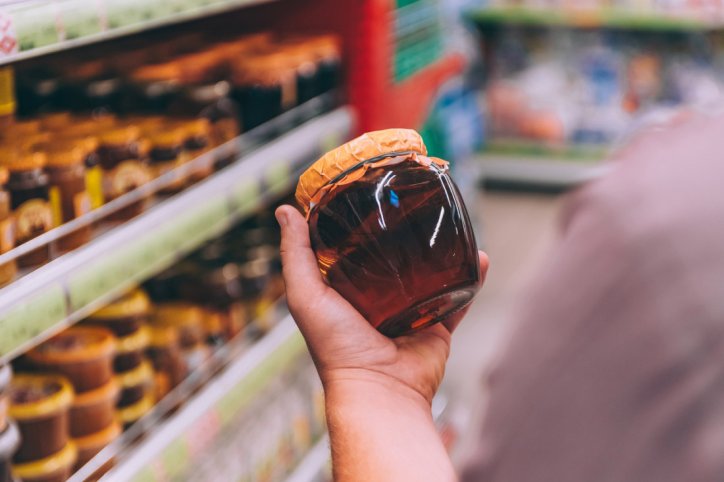 Ein prüfender Blick auf das Honigglas in einem Supermarkt