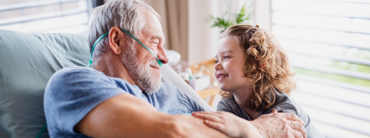 Senior empfängt Enkelin nach Bypass-Operation im Krankenhaus.