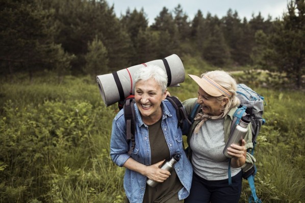 Zwei Frauen Mitte 60 sind gemeinsam auf einer Wanderung in der Natur